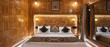 Un dormitorio con paneles de madera, una cama grande, luces fijadas en la pared y un espejo que refleja la habitación.