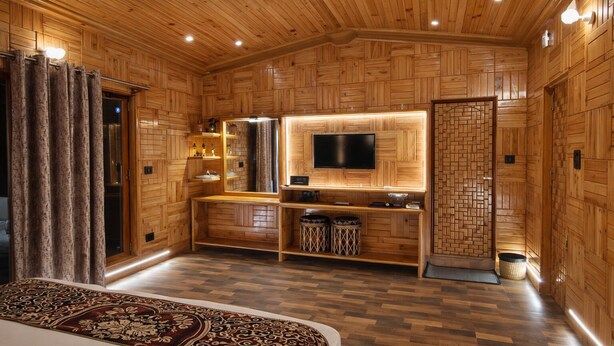 Een houten interieur met een bed, een televisie en een kleine kitchenette.
