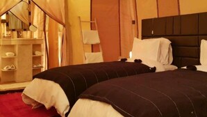 A tent-style room with two beds, a wardrobe, and a mirror. - Les Pyramides Merzouga Camp (Merzouga)