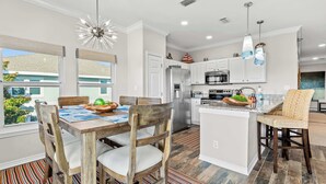 A modern kitchen with white cabinetry, stainless steel appliances, and a central island.