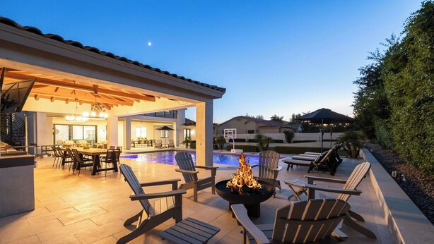 A covered outdoor area with a pool, lounge chairs, and a fire pit. - Luxury Outdoor Living - Heated Pool and Hot Tub (Chandler)