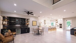 A spacious kitchen with a central island, modern appliances, and a dining area with a round table and chairs. - Luxury Outdoor Living - Heated Pool and Hot Tub (Chandler)