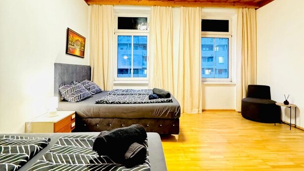 Une chambre avec deux lits, un plafond en bois et des fenêtres avec des rideaux.