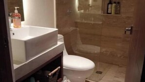 A bathroom with a white sink, a toilet, and a shower area. - Practical and Comfortable Loft (Tulum)