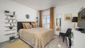 A modern bedroom with a bed, bedside tables, a desk, a chair, a window, and a mirror. - Apartment 'Gudrun' with Sea View, Wi-Fi and Air Conditioning (Praia do Carvoeiro)