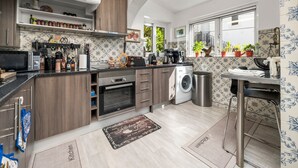 A modern kitchen with wooden cabinets, a built-in oven, and a coffee machine. - Apartment 'Gudrun' with Sea View, Wi-Fi and Air Conditioning (Praia do Carvoeiro)