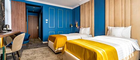 Una habitación de hotel con dos camas, un escritorio y una silla.