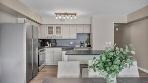 Una cucina moderna con mobili bianchi, un piano di lavoro in marmo e un forno integrato.