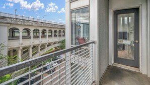 Un balcone con vista su un ponte e un edificio con ampie finestre e un ingresso.