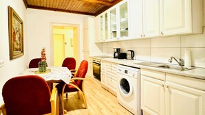 Une cuisine compacte équipée d’un lave-linge, d’une machine à café et d’un évier.
