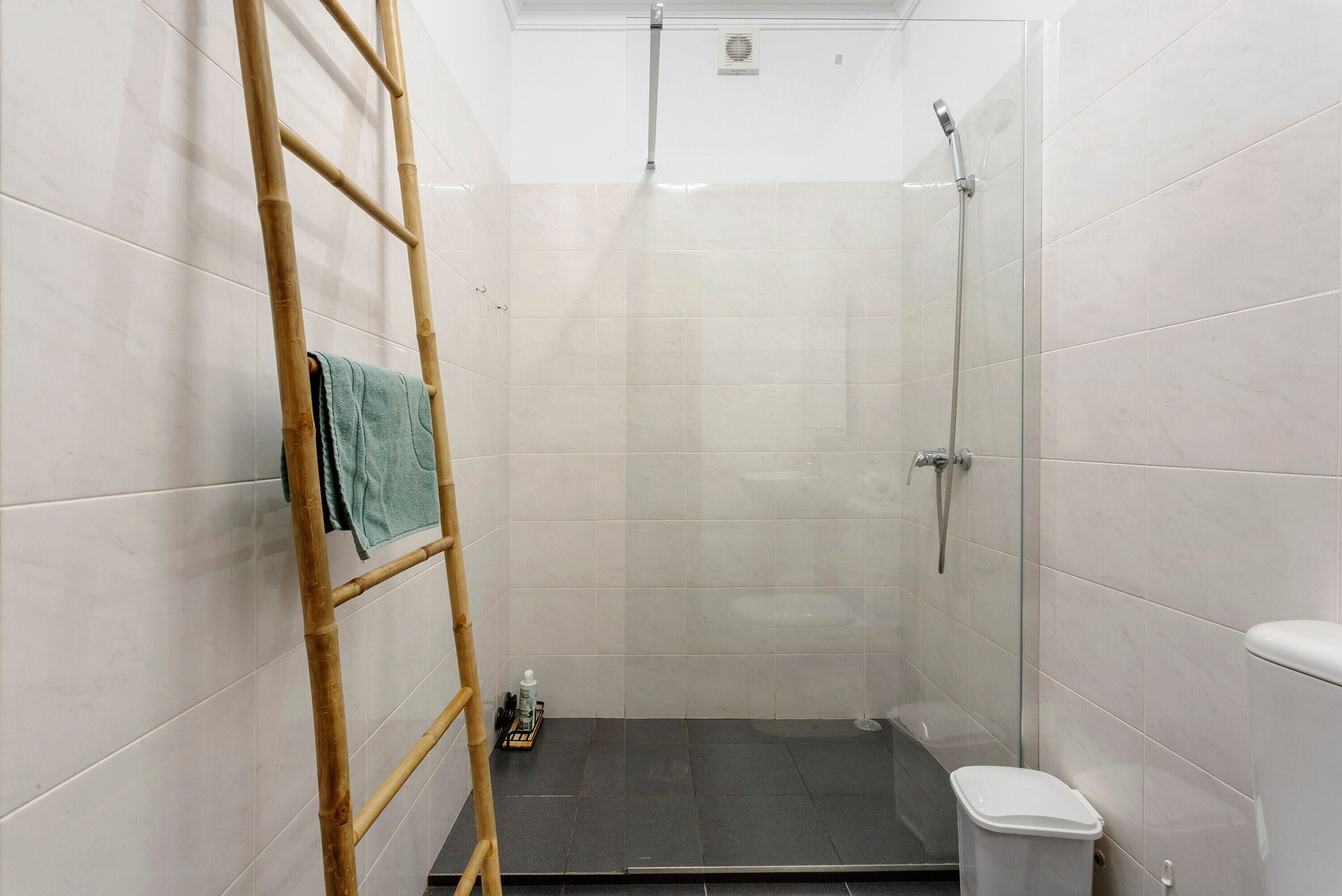 Une salle de bain équipée d’une douche, de toilettes et d’un porte-serviettes.