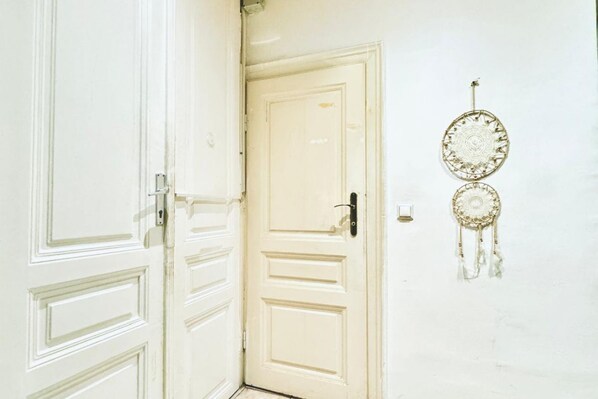 A white door with a keyhole and a dreamcatcher on the wall. - Inviting Getaway | 10 Minutes from FAC Platz (Vienna)