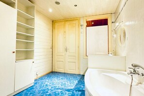 A bathroom with a bathtub, a mirror, and a shower. - Inviting Getaway | 10 Minutes from FAC Platz (Vienna)