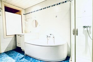 A bathroom with a bathtub, a shower, and a mirror. - Inviting Getaway | 10 Minutes from FAC Platz (Vienna)