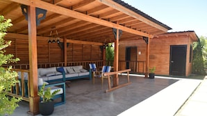 A covered outdoor seating area with a wooden bench, a sofa, and a table. - Villa Dulce Refugio (Cabrera)