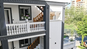 A multi-story building with balconies, staircases, and outdoor seating. - Hotel Vila Aaron (Manëz)