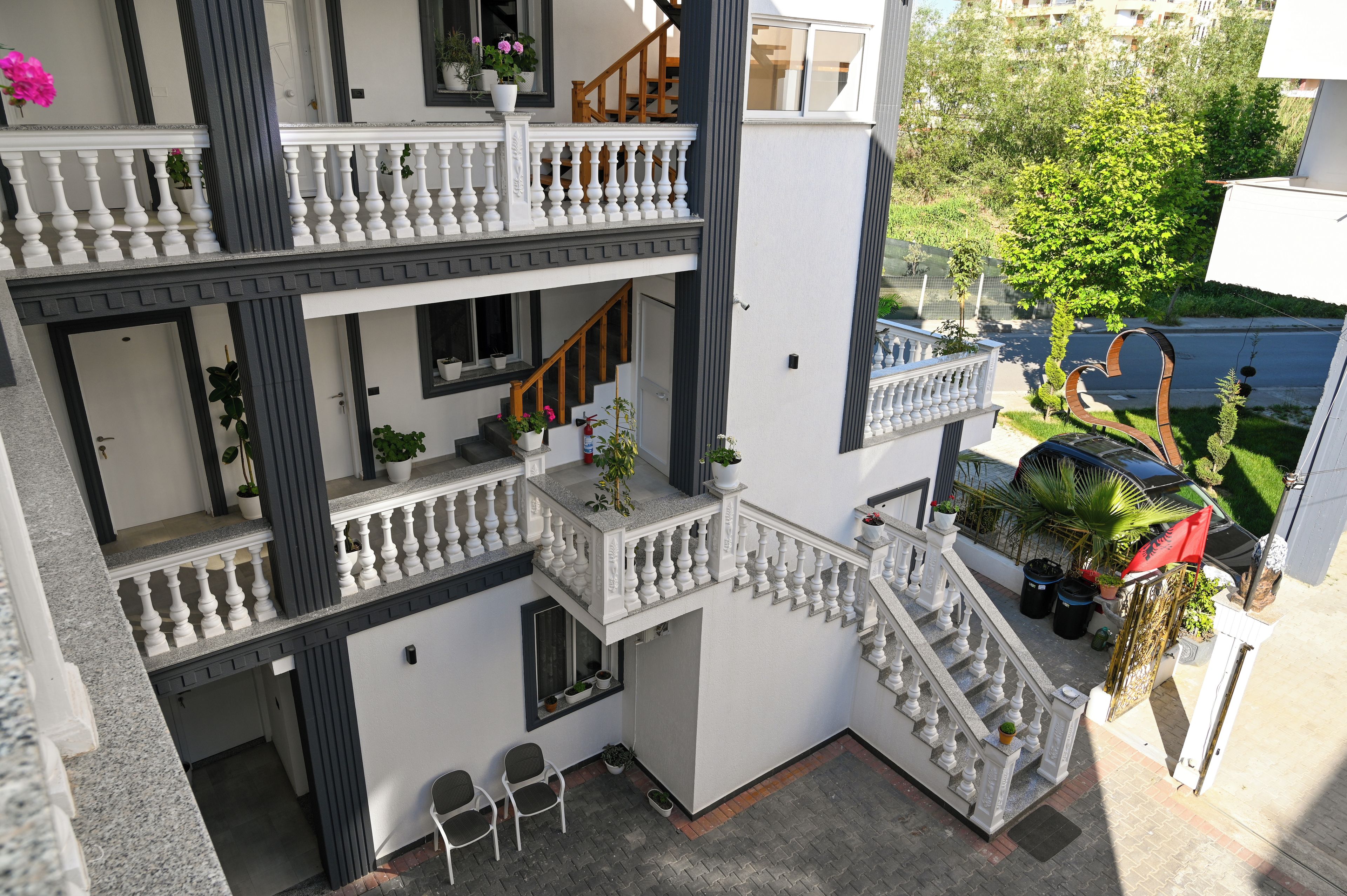 A multi-level residential building with balconies, staircases, and outdoor seating areas.