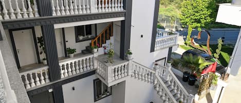 A multi-level residential building with balconies, staircases, and outdoor seating areas.