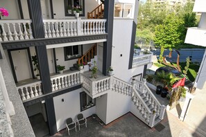 A multi-level residential building with balconies, staircases, and outdoor seating areas. - Hotel Vila Aaron (Durrës)