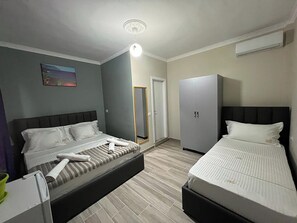 A hotel room with two beds, a wardrobe, a mirror, and a ceiling light. - Hotel Vila Aaron (Durrës)