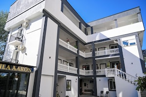 A modern multi-story building with balconies, a staircase, and a sign reading "ILA AARON". - Hotel Vila Aaron (Durrës)