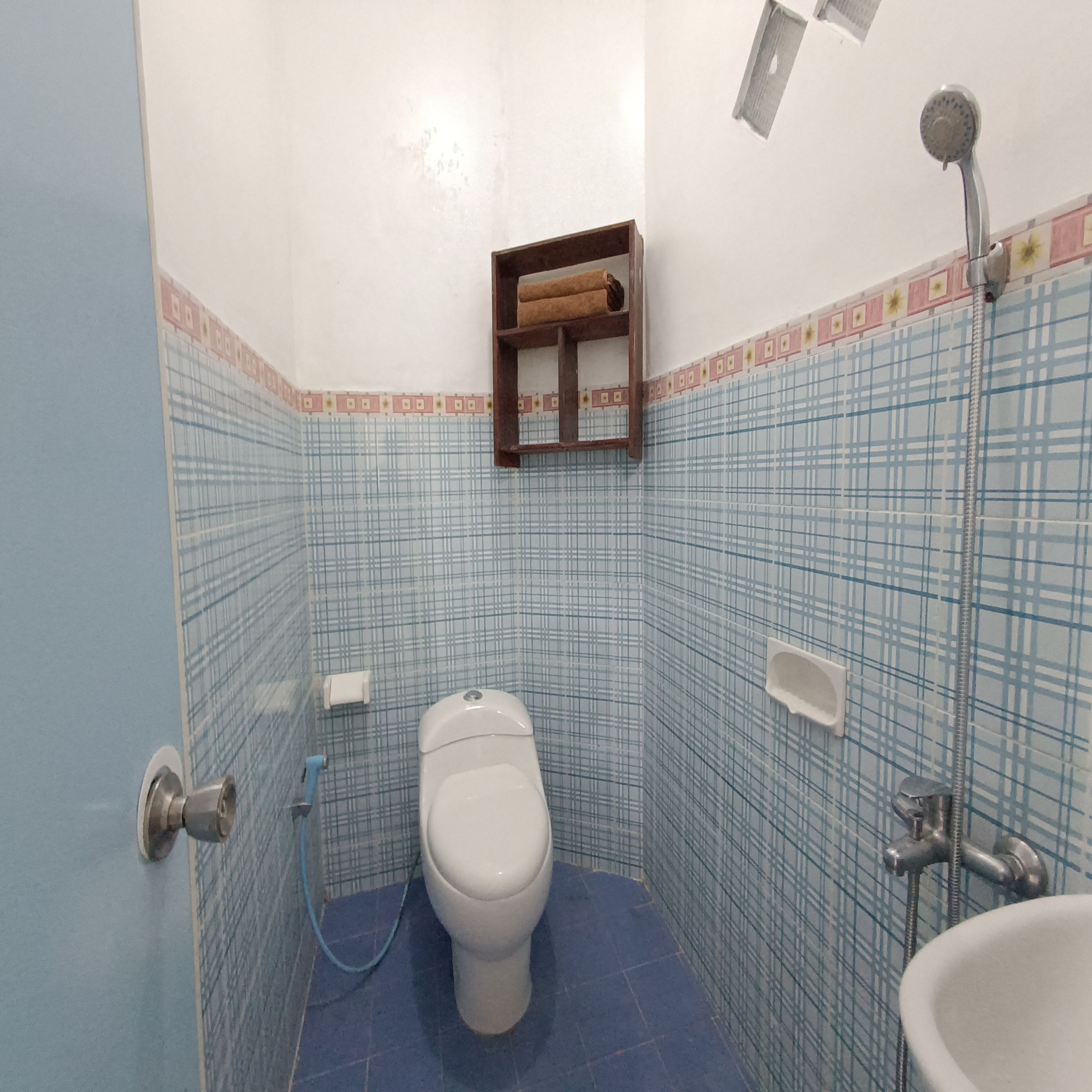 Baño pequeño con inodoro, lavabo y ducha.
