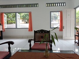 A room with a large window, a chair, a table, and a door.