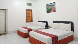 A hotel room with two beds, a painting on the wall, and a window with curtains. - Hotel STIPRAM Kaliurang Yogyakarta (Pakem)