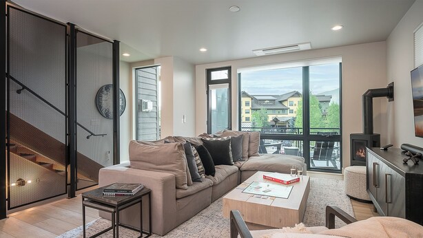 A modern living room with a sofa, coffee table, and a fireplace.