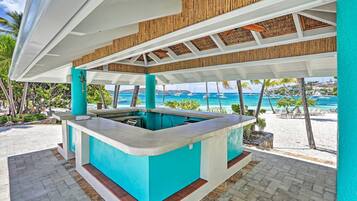 A poolside bar area with a view of the beach and ocean.