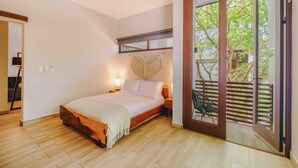 Un dormitorio con cama de madera, lámparas de noche y vistas a un balcón con una silla.