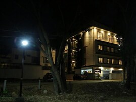 Un edificio de varios pisos con un restaurante en la planta baja y un área de estacionamiento.