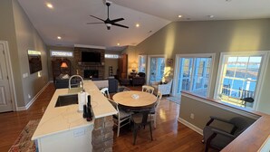 A spacious living area with a fireplace, a dining table, and a kitchen island. - NEW KI Creek Retreat! 3BR/2bath water view, private house near KI wedding venues (Stevensville)