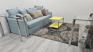 Un salon moderne avec un canapé bleu clair, une table basse jaune et une table basse en verre.