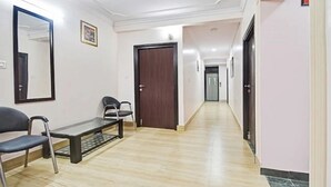 A hallway with a bench, chairs, and a door.