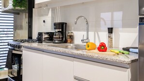 A modern kitchen with a microwave, toaster, coffee maker, and a sink. - Penthouse | Unbeatable Views | 24-Hour Concierge | Outdoor Gym | Pet-Friendly (Montevideo)