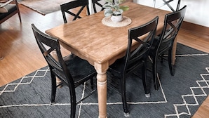 A dining area with a wooden table, black chairs, a woven placemat, and a hanging pendant light. - Bricks - Main floor 2 bed/bath home, 2 car garage 3 blocks from Mayo Clinic! (Rochester)