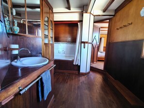 Un intérieur en bois comprenant un évier, un miroir et un espace douche.