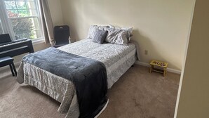 A bedroom with a bed, a chair, a small table, and a window. - Beautiful 3 Bedroom condo apt near Owl's Nest golf course and wedding venue (Thornton)
