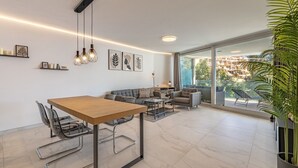 A modern living room with a dining area, large windows, and a view of the city. - Seaview Splendor 2-BR luxury, huge terrace (Fuengirola)