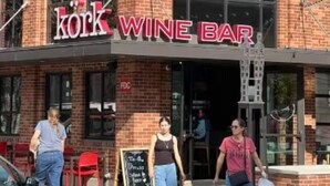 Un bâtiment en briques sur lequel on peut lire l’inscription : « Kork Wine Bar ».