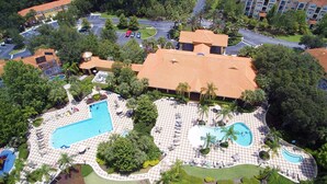 An aerial view of a resort with multiple swimming pools, lounge areas, and a parking lot. - EV_3169 - 4 Bed 3.5 Bath Townhome with Screened-In Private Pool (Kissimmee)