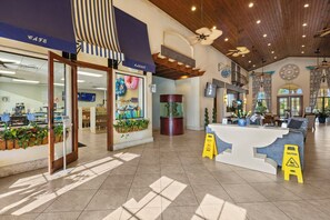 Un hall d’entrée spacieux comprenant un comptoir d’accueil, un café et un grand aquarium.