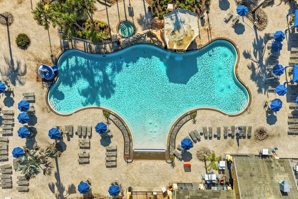 An aerial view of a swimming pool with lounge chairs and umbrellas.