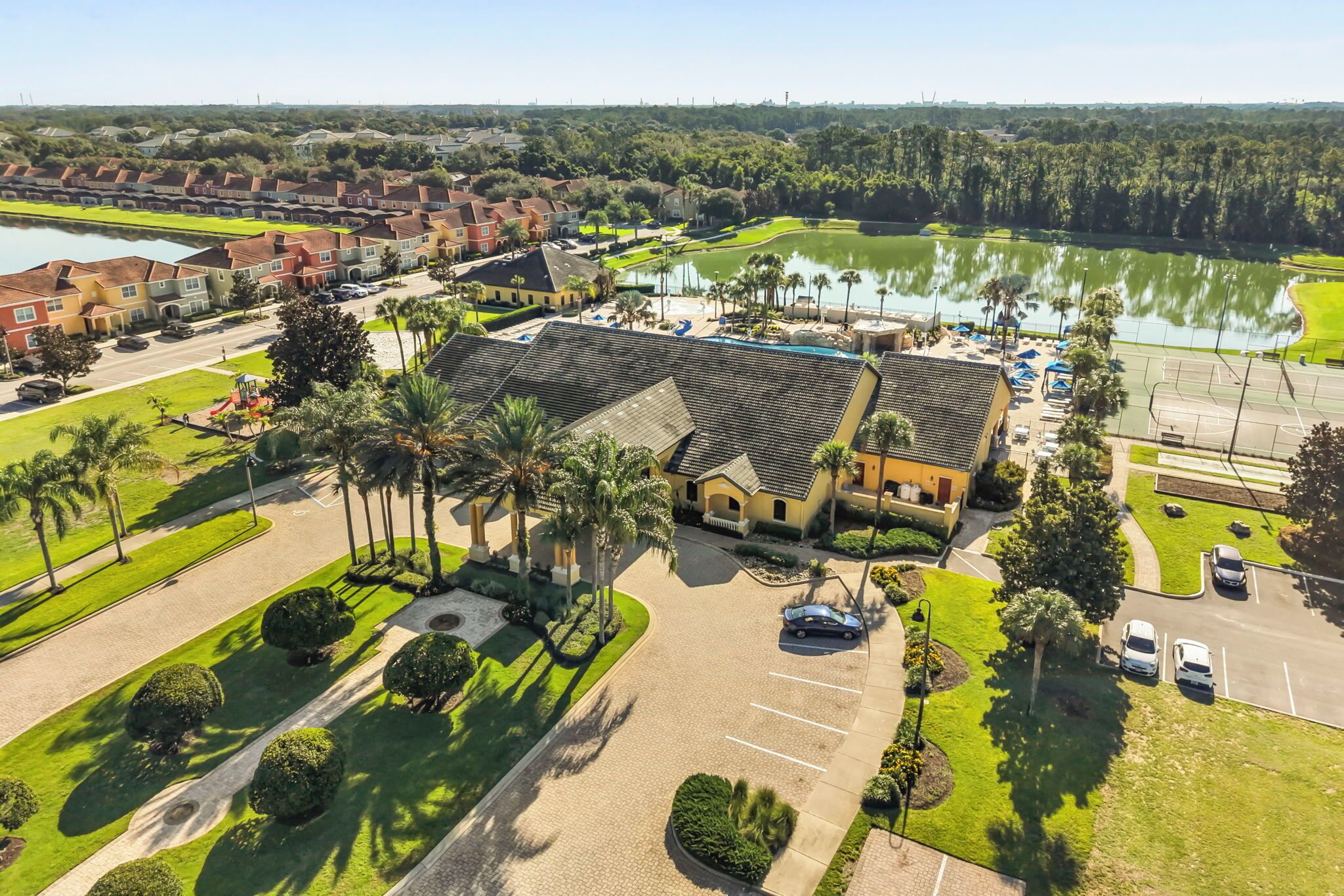 A residential area with a large building, a parking lot, and a body of water.