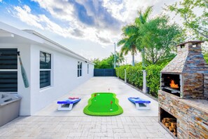 Ein Garten mit Putting Green, Grill und Bootsgeräteschuppen.