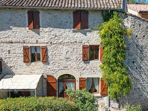 A stone building with multiple windows, a covered entrance, and a vine-covered wall. - Charming Cottage in Milhars, Between Bastides and Valleys (Milhars)