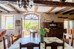 A rustic dining room with a wooden table, chairs, and a chandelier. - Charming Cottage in Milhars, Between Bastides and Valleys (Milhars)