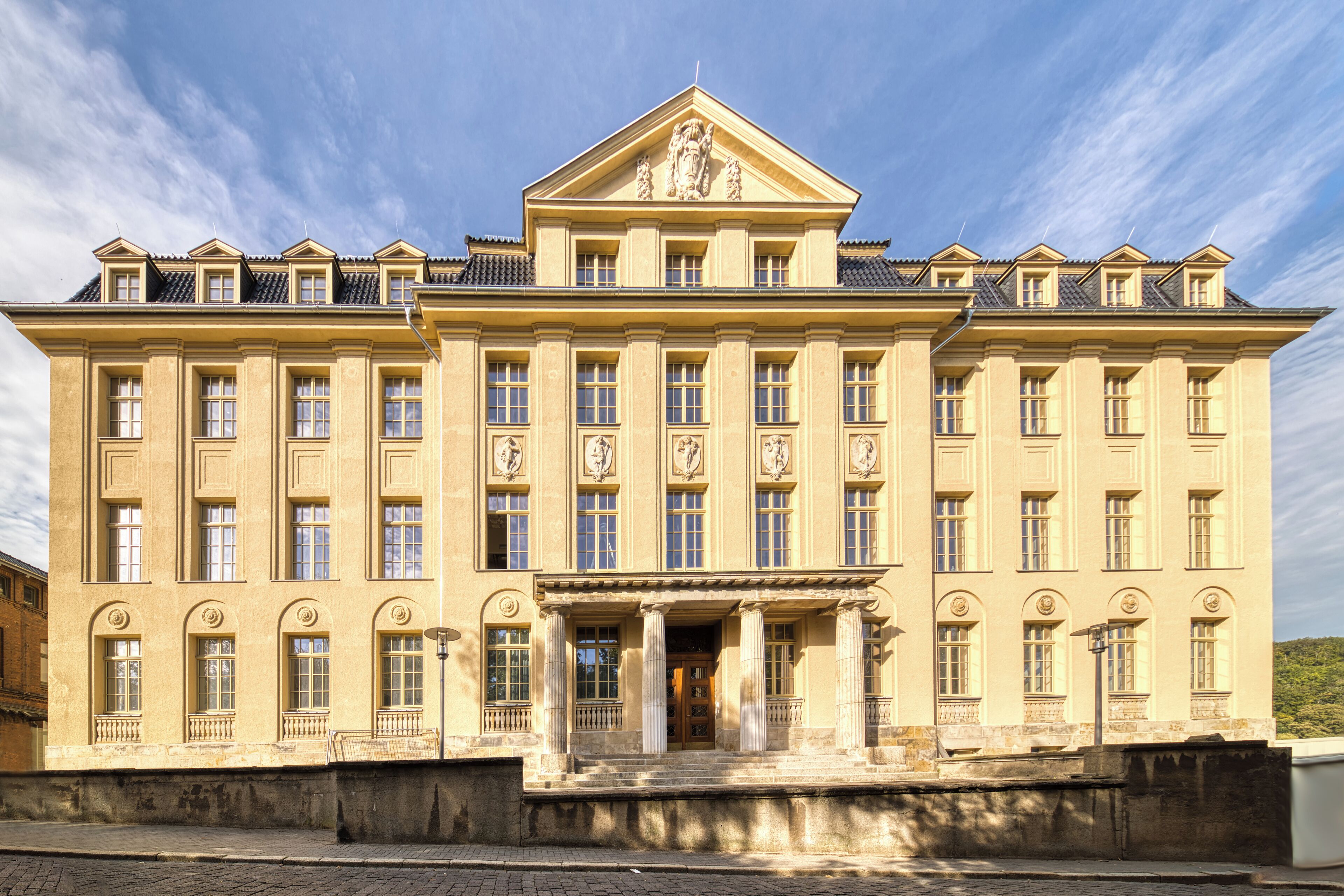 A large, stately building with a symmetrical facade, multiple windows, and a central entrance with columns.