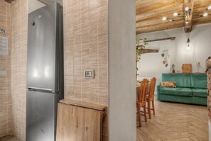 Une cuisine moderne dotée d’un réfrigérateur en acier inoxydable, de meubles en bois et d’un dosseret carrelé.